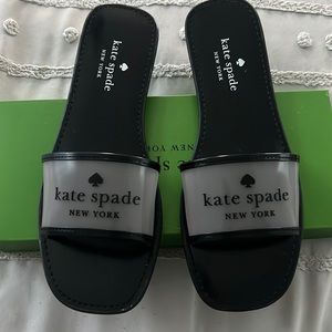 Black clear sandals with the words Kate Spade in the front. Never been worn
